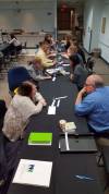 Long table with the following people (front to back) talking one-to-one across from each other: Vickie Collins with Gordon Reddick, Sheila Miller with (can't make out who), Will Reed with Nancy VerBurg, there are more, but can't make them out.