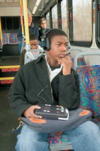 Man riding on bus and listening to a NLS digital book
